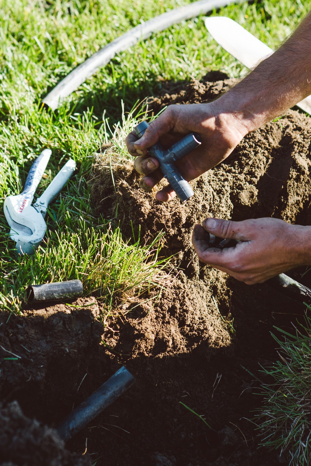 Travail manuel sur une conduite d’irrigation dans une tranchée