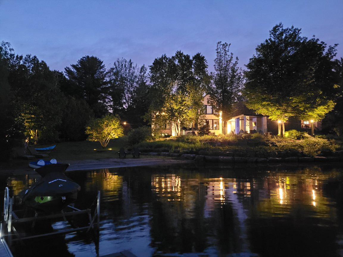 Résidence éclairée et reflets sur le lac au crépuscule