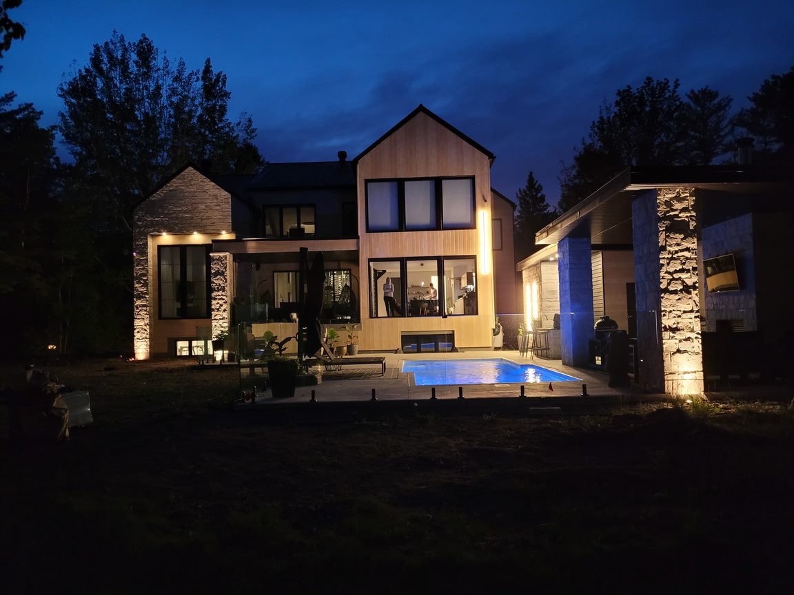 Maison contemporaine et piscine éclairées en soirée